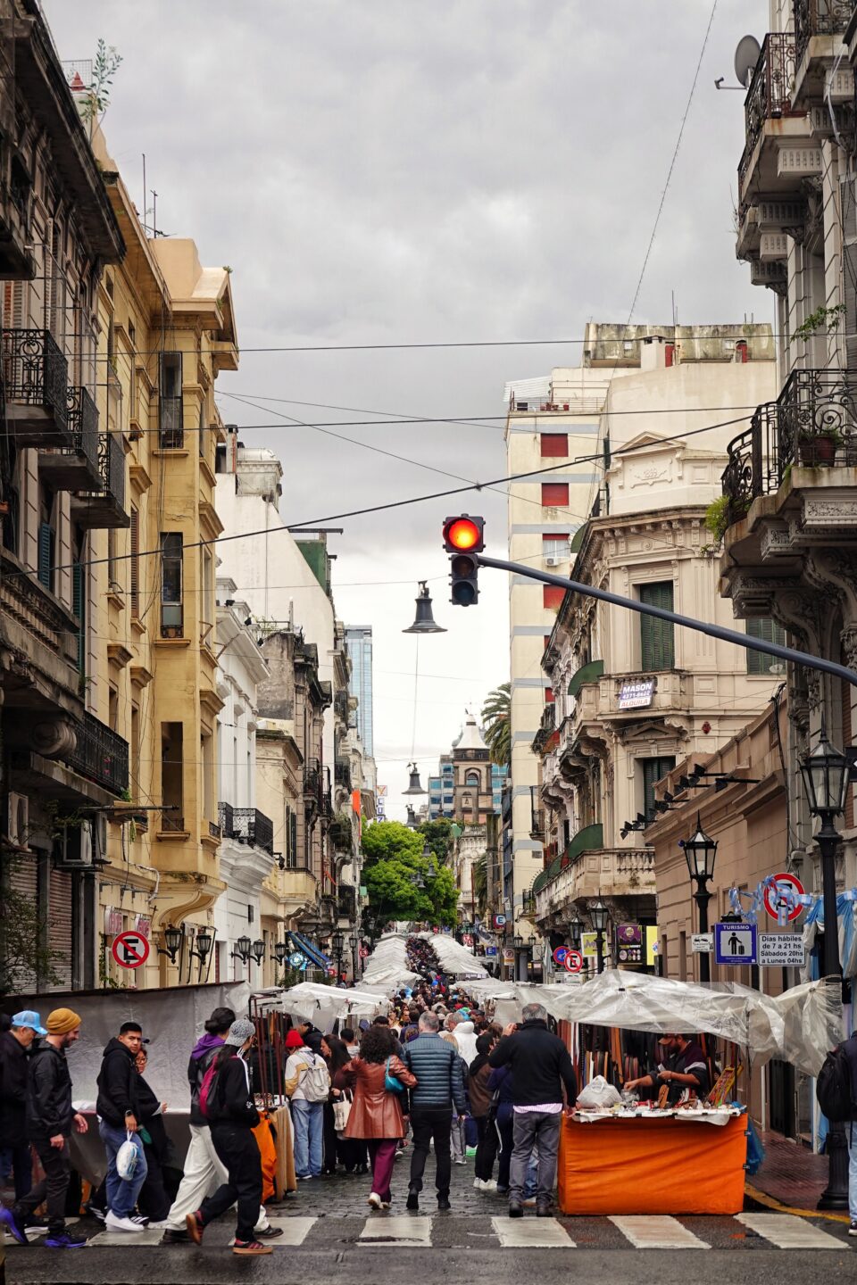 Calle con puestos de feria y mucha gente entre edificios antiguos de San Telmo