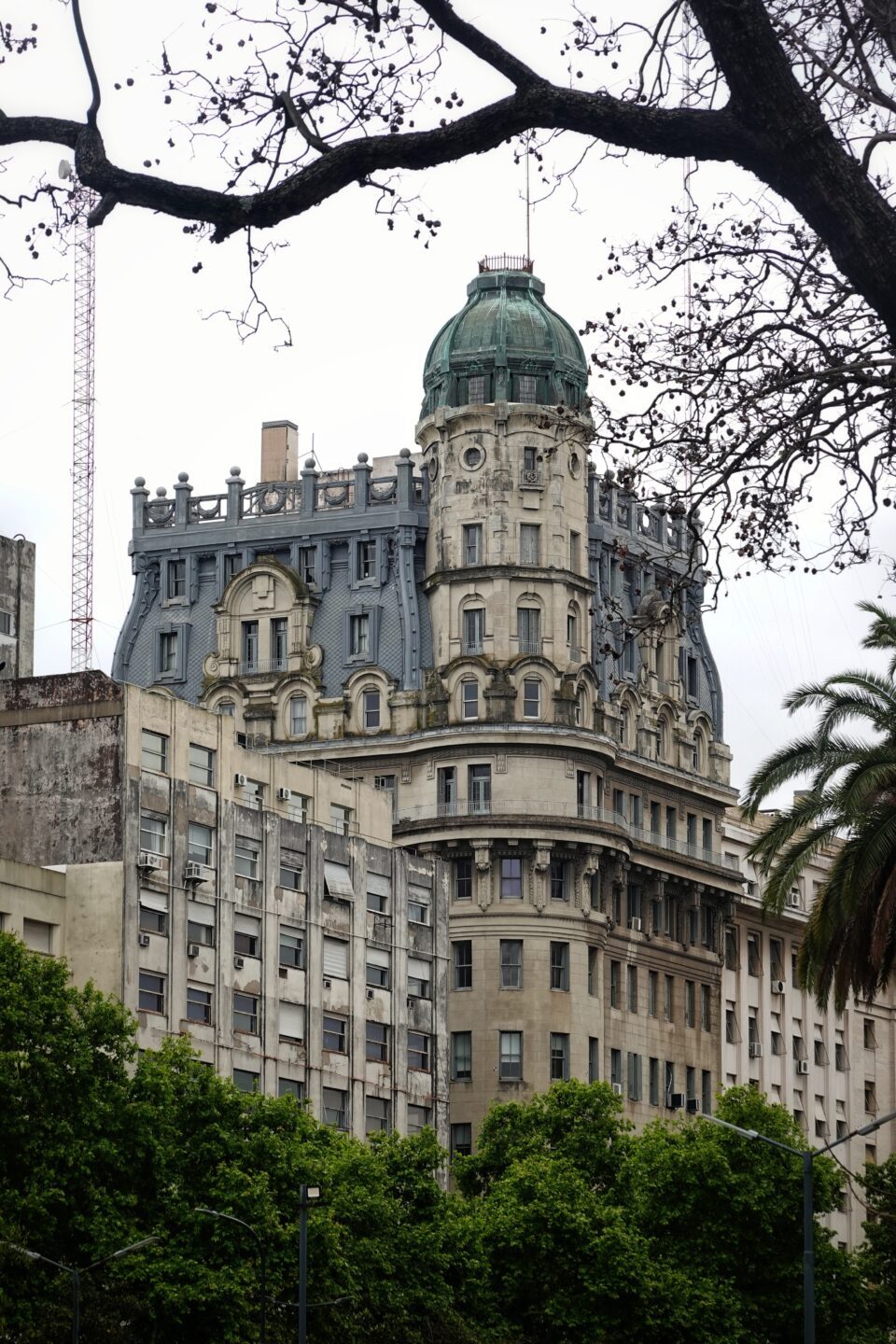 Edificio señorial con cúpula verde entre los árboles de Buenos Aires