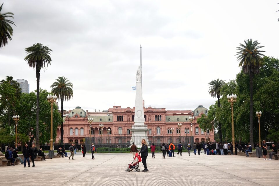 Plaza de Mayo con la Casa Rosada al fondo, la Pirámide de Mayo y gente paseando