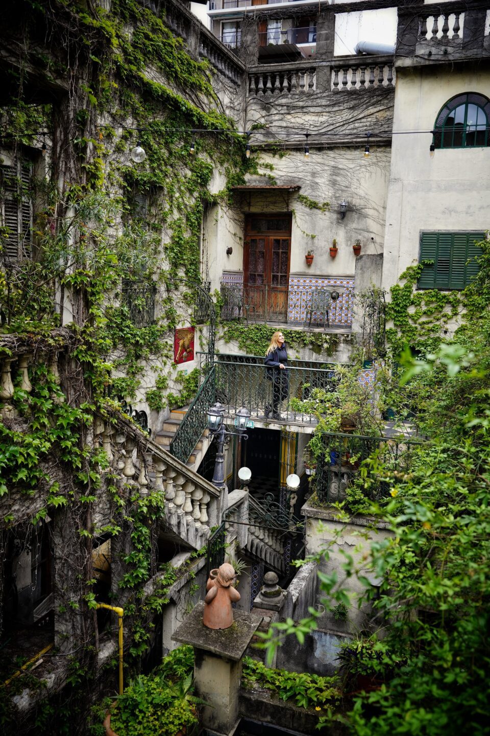 Edificio antiguo cubierto de hiedra con una escalera de piedra en Buenos Aires